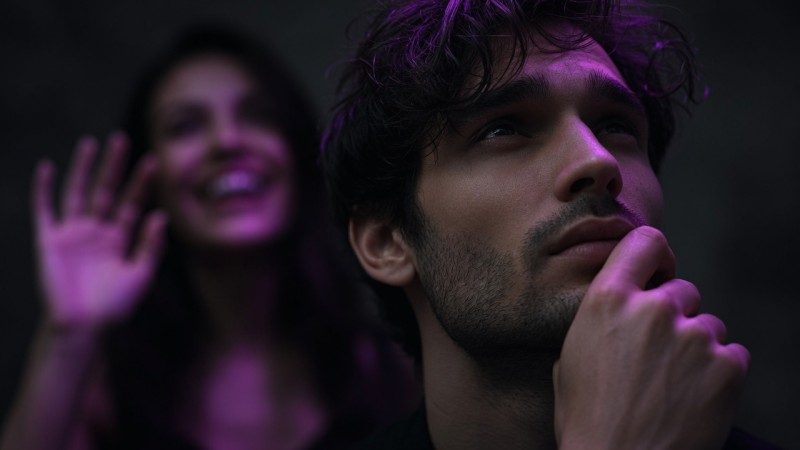 Man thinking about a date idea while the woman waves at him impatiently
