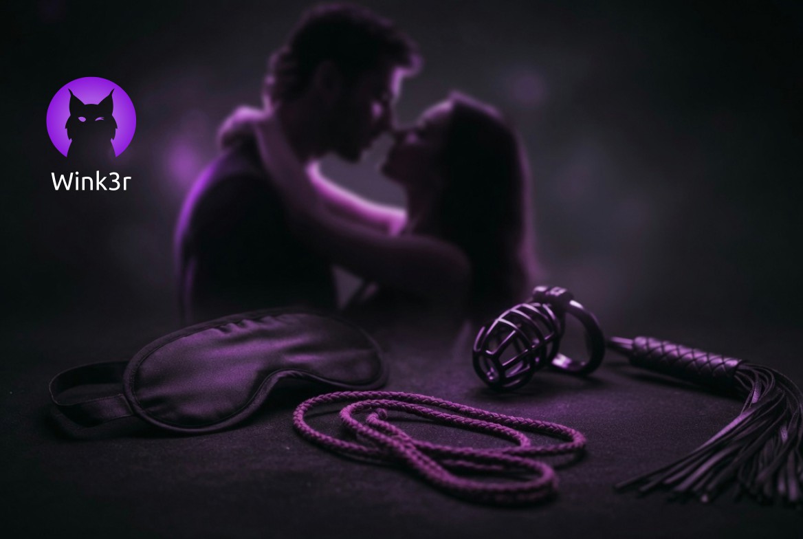 Na pierwszym planie leżąca na stole opaska na oczy, lina do shibari, chastity cage i pejcz, a w tle całująca się para